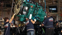 Workers at Volvo Trucks&rsquo; New River Valley assembly plant in Dublin, Va. lower a Volvo D13 engine onto a chassis