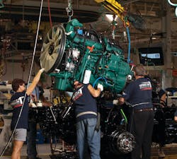 Workers at Volvo Trucks&rsquo; New River Valley assembly plant in Dublin, Va. lower a Volvo D13 engine onto a chassis
