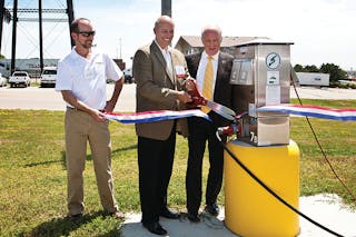 Donn Quinn, president of Sapp Brothers, cuts the ribbon to officially open truckstop electrification at Sapp Brothers in Omaha, Neb. Quinn is joined by Paul Clarke (left), site development specialist for Shorepower, and Omaha Mayor Jim Suttle.