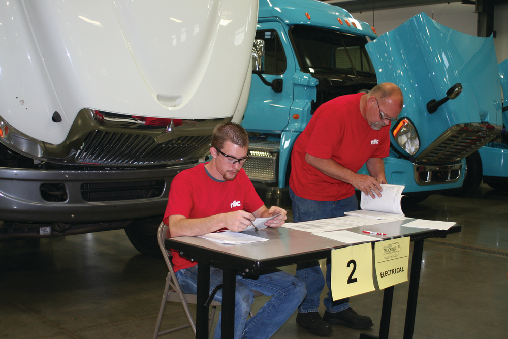 Jacob Gaylor, Mid-America Technology Center post-secondary student, ponders an electrical problem alongside Clarence Preston, Cummins Southern Plains technician, in the 2012 Oklahoma SuperTech Competition. Gaylor won 1st place honors in the student category and also won the Fastener Work Station.
