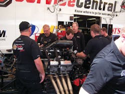 A pit crew disassembles a race car engine at Lucas Oil Raceway.