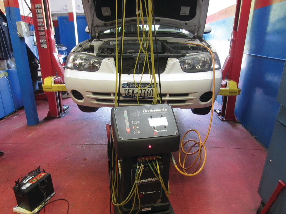 Bleeding the brakes with a brake flush machine. Notice that a battery is not directly on the floor. This is in accordance with EPA regulations in order to prevent fines. For more information on the Flo-Dyamics BrakeMate Jr. check out VehicleServicePros.com/10106064.
