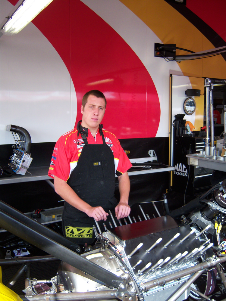 Jessie Snyder of the Kalitta Motorsports crew prepares to disassemble the engine.