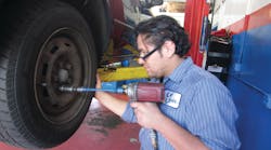 Figure 6: A mechanic using a torque stick to properly tighten lug nuts. Figure 6: A mechanic using a torque stick to properly tighten lug nuts.