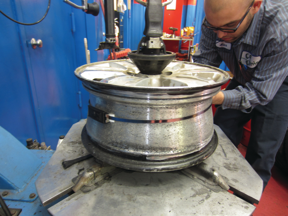 The ingredients to a no-comeback tire job on a Ford Explorer with an aluminum rim: sanding the rim down, painting on bead sealer, lubing the new valve stem and the tire itself with non-corrosive tire lubricant, and on this vehicle properly replacing the broken TPMS sensor.