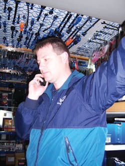 Shane Sutton takes a call from a customer while servicing an account.