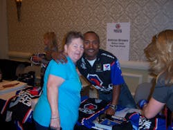Matco Tools Top Fuel Driver Anton Brown signs t-shirts and greets attendees at the trade show.