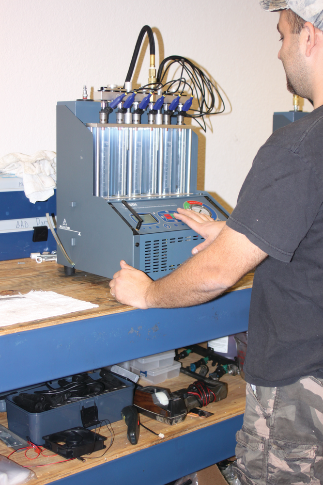 A technician tests a set of Bosch fuel injectors.