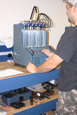 A technician tests a set of Bosch fuel injectors.
