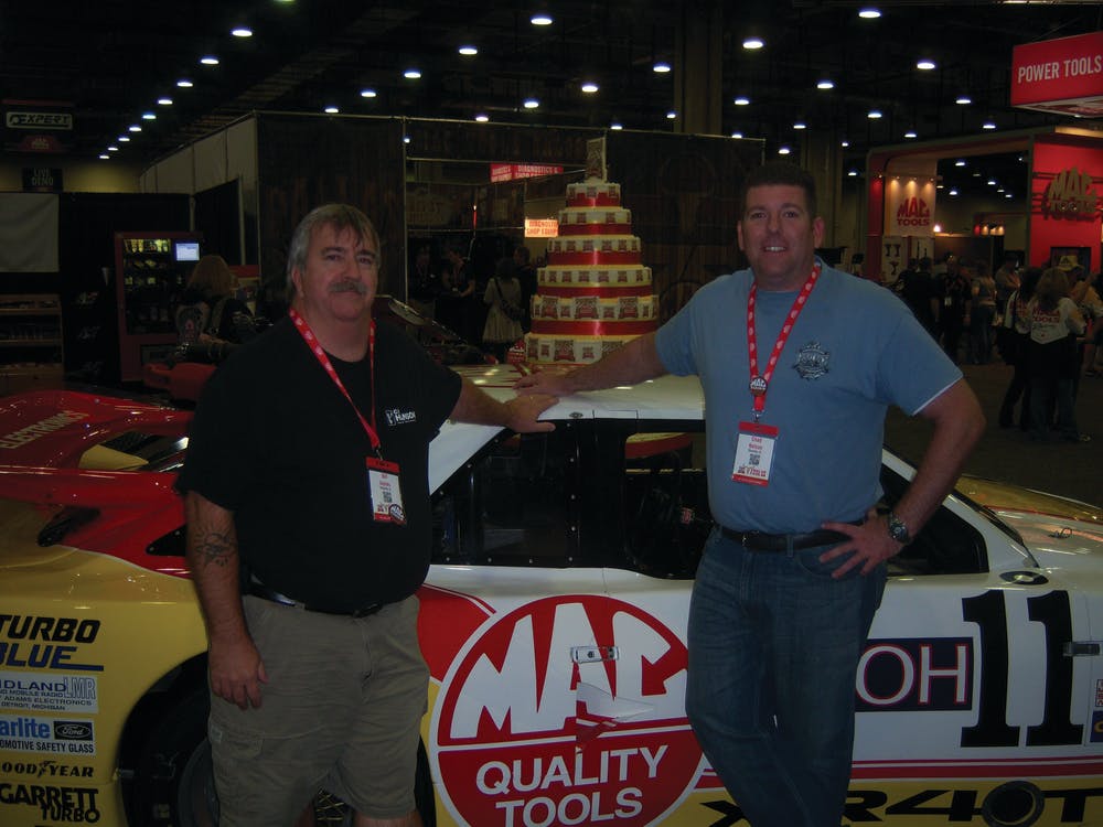 Bill Jaynes, left, and Chad Nelson of Titusville, Fla. enjoy race cars at the Mac Tools Tool Fair in Dallas, Texas. For more show photos, go to www.vehicleservicepros.com/10888366.
