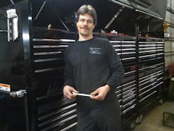 Mike Pope posing in front of his giant Mac toolbox, holding his famous 7/16&apos; wrench.