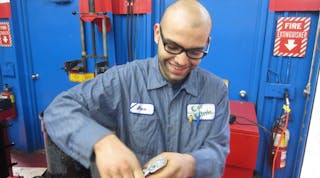 Alex Portillo repairing damaged threads on a strut from a 1996 Nissan Maxima.
