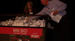Bruce Weber, president of ISN, draws the name of a cash prize winner during the awards dinner, assisted by Melissa Sanders.