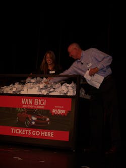 Bruce Weber, president of ISN, draws the name of a cash prize winner during the awards dinner, assisted by Melissa Sanders. Bruce Weber, president of ISN, draws the name of a cash prize winner during the awards dinner, assisted by Melissa Sanders.