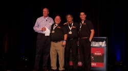 Bruce Weber of ISN, left, honors Jeff Whisen, Manny Occiano and Joshua Carton of Power Probe for having the most exciting booth demos at the trade show.