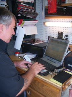 Bill Jaynes rings up a sale using a customer's credit card. Bill Jaynes rings up a sale using a customer's credit card.