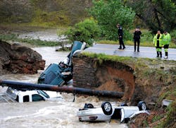 Officials investigate the scene of a road collapse at Highway 287 and Dillon at the Broomfield/Lafayette border, Colo., that sent three vehicles into the water after flash flooding on Thursday, Sept. 12, 2013. The National Weather Service has warned of an &apos;extremely dangerous and life-threatening situation&apos; throughout the region. (AP Photo/Daily Camera, Cliff Grassmick)