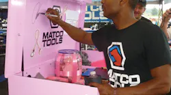 Matco Tools dragster Antron Brown signs the pink Matco Toolbox that was a raffle prize in a fund raiser for breast cancer awareness.