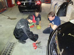 Manning presents pliers in a body shop. Manning presents pliers in a body shop.