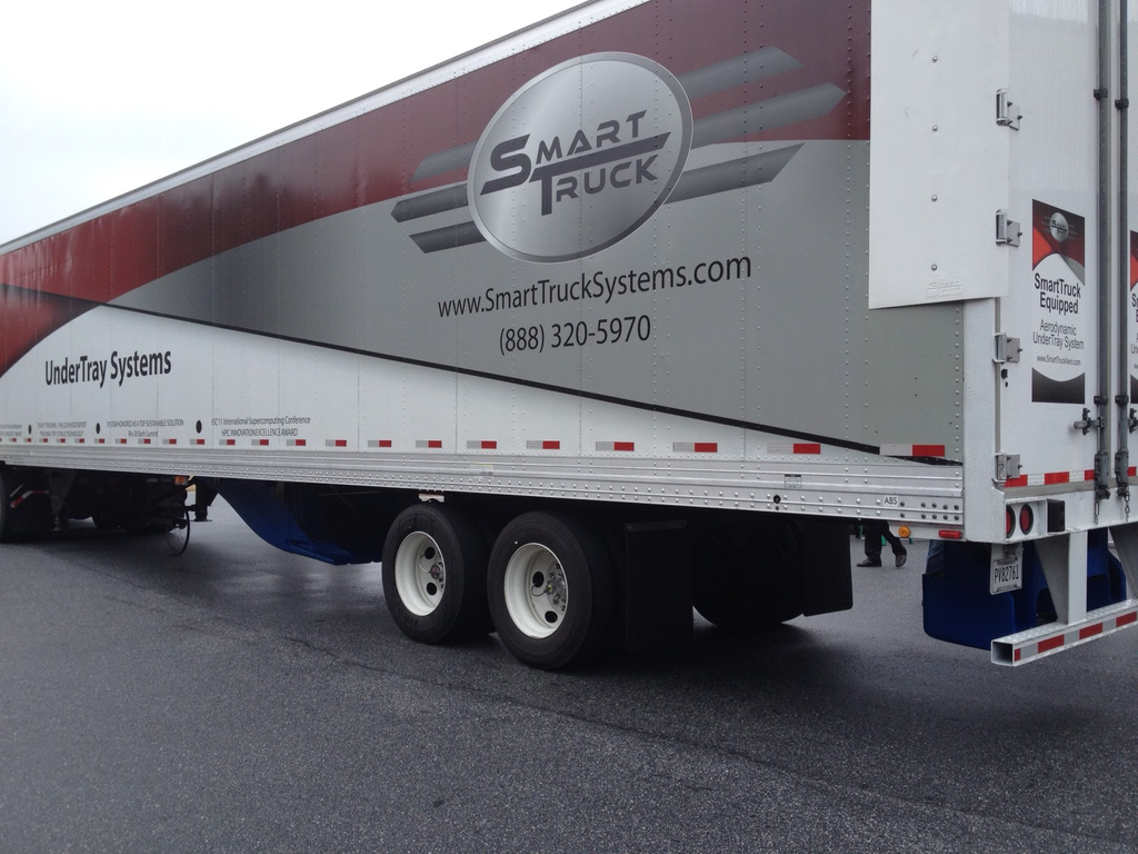 This photo shows three of the four aerodynamic device components that fleets can equip on their trailers. The undertray (blue) at the bottom middle of the trailer, the rear diffuser (blue) at the bottom back of the trailer, and the AeroEdge side fairings (white) at the top back part of the trailer.