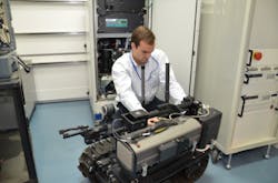A TARDEC engineer integrates a hydrogen fuel cell onto a small tracked robot in the Fuel Cell lab at the GSPEL.
