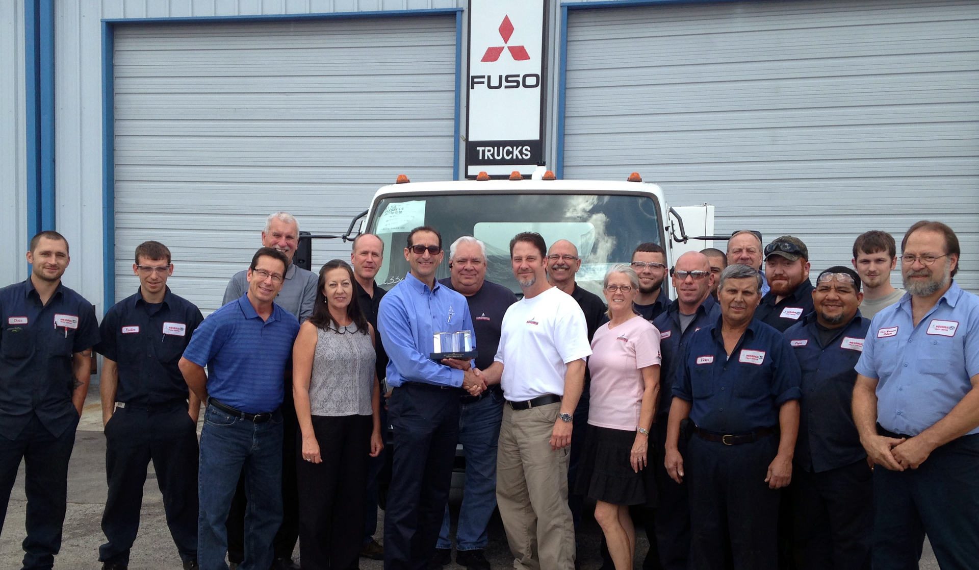Todd Bloom (center left), MFTA's President & CEO, presents the Mitsubishi Fuso North American Dealer of the Year Award to Frank Messina, dealer principal, as he is joined by other employees of Messina Truck Center, Tampa, Fla.