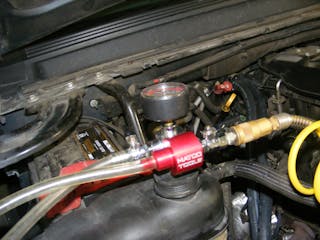 Fig. 10: After replacing the hoses, thermostat and hose clamps, place the vacuum lift tool on the radiator or reservoir fill neck. You will then use shop air connected to the air lift tool to create a vacuum in the cooling system by a venturi effect of the shop air passing through the tool. Once a system vacuum of approximately 25&rdquo; is achieved, disconnect the shop air and note the vacuum reading on the tool&rsquo;s gauge.