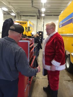 Mac Tools distributor Jim Bernard meets a customer while dressed up in his Santa Claus ensemble.