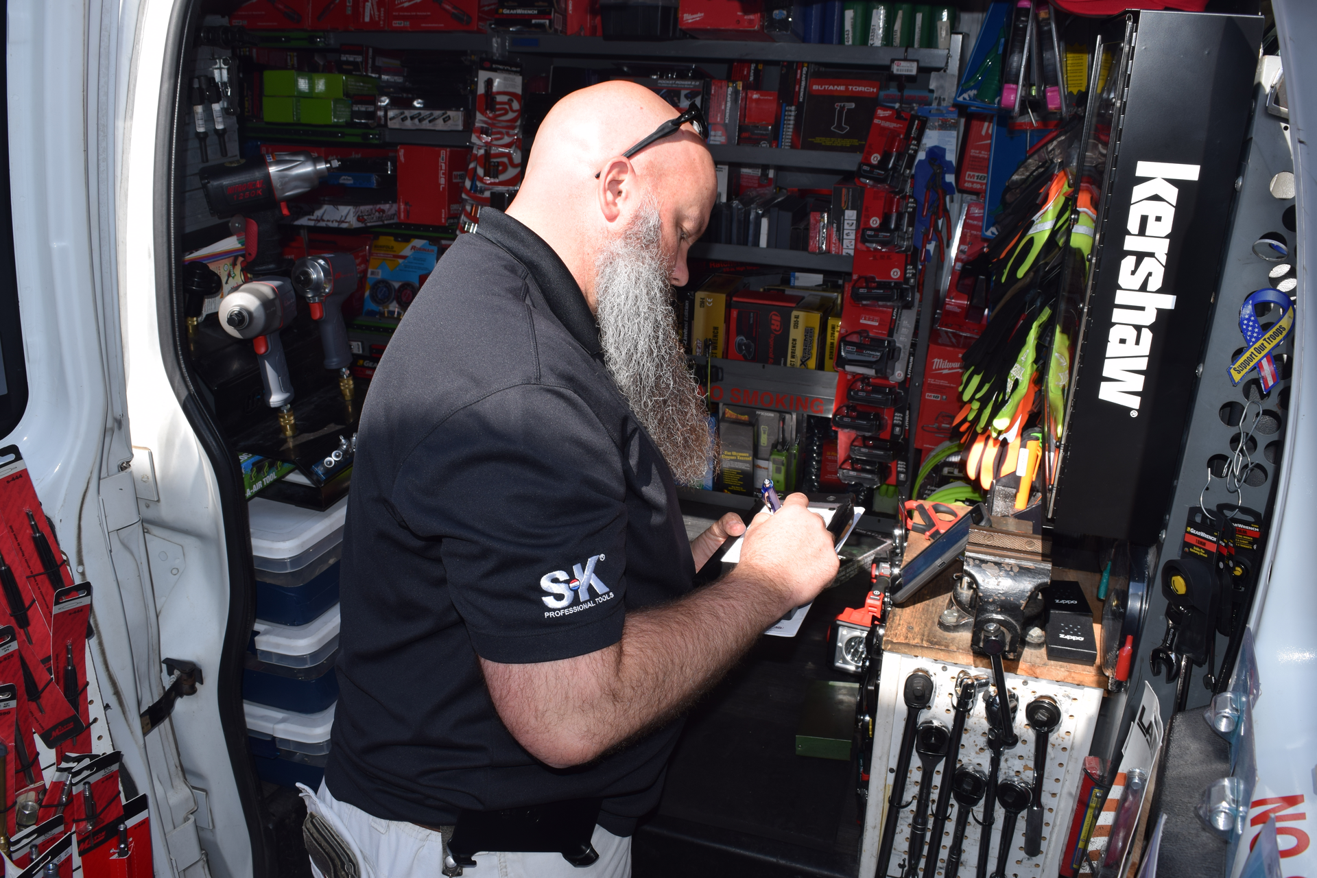 Jenkins Jr. writes up a sales ticket for a customer at a shop. To the right, his vise is situated to service and repair customer tools.