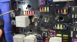 This image is the top view of the fuse/relay center. note the burned area below the white relay in the upper middle section. This is where the technician mistakenly applied an unfused wire to a ground which started the fire.