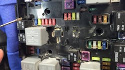 This image is the top view of the fuse/relay center. note the burned area below the white relay in the upper middle section. This is where the technician mistakenly applied an unfused wire to a ground which started the fire.