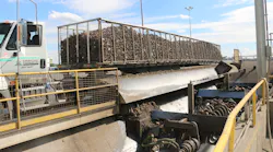 Each trailer is driven onto the wet hopper and tilted to the side to dump the sugar beets.