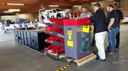 Heavy duty inground lift sales manager, Matthias Lennemann (in blue blazer), shows attendees the workings of a Stertil-Koni Ecolift at a recent education and safety forum hosted by Southwest Lift &amp; Equipment in San Bernardino, Calif.
