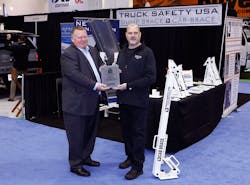 Truck Safety USA&apos;s Jamie Hendricks receives The Work Truck Show 2020 Innovation Award, safety category, for the company&apos;s Cab Brace, from NTEA President and CEO Steve Carey.