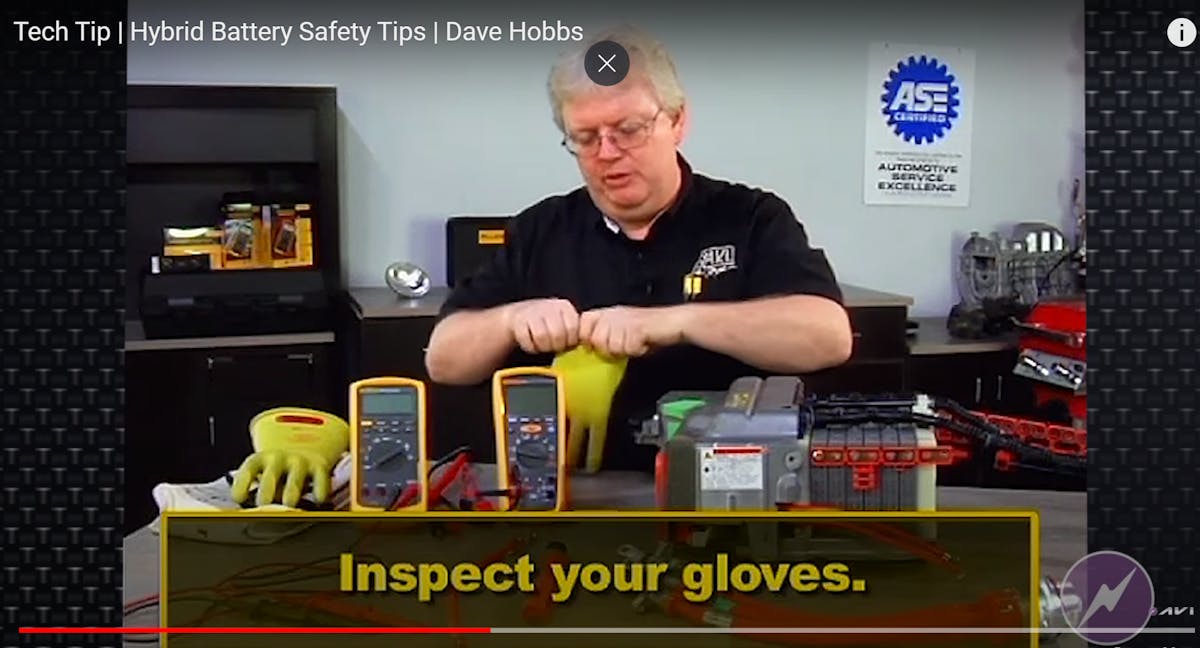 Dave Hobbs demonstrating a field test of the Class-Zero rated gloves. These gloves are the personal protection equipment (PPE) used to insulate the user safely, up to 1000 VAC, and can only do so effectively if no holes exist. Dave is seen here filling the gloves with air to check for leaks.