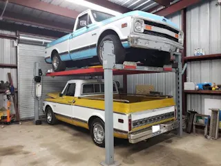 Advantage DX-9000-XLT wide four-post car lift with boxed posts supporting a full-size vehicle