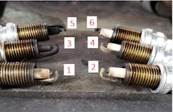 Figure 3 - Pictured are all six of the engine&rsquo;s spark plugs. Two of which are particularly carbon-fouled. The results of a an overly-rich fuel mixture, only effecting two cylinders offers a clue. It not only eliminates components as being &ldquo;suspects&rdquo; (like MAF / MAP /HO2 Sensors) but also dictates the diagnostic path to follow.