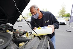 An Alliance Parts Warehouse, Inc. employee refills wiper fluid as part of APW’s “Be Car Care Aware” event April 16, 2021.