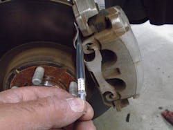 Figure 1 -Technician using a brake pad thickness gauge. Figure 1 -Technician using a brake pad thickness gauge.