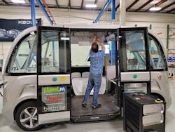 A technician performs maintenance on a Navya Autonom Shuttle Evo. Even without a diesel, or gasoline-powered engine, the shuttle still requires maintenance on interior components, brakes, suspension, wheels, and tires.