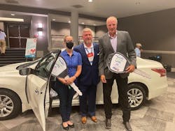 Randi Ruthart-Garrison is presented a 2014 Ford Fusion, refurbished by Town East Ford, by NABC Immediate Past Chair Darren Huggins (c.) and Don Porter, CEO of URG.