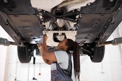 Female auto repair technician working under car Female auto repair technician working under car
