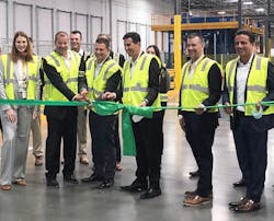 Members of the MANN+HUMMEL team, with representatives from DHL present, cut a green ribbon to signify the opening of the new West Coast Distribution Center. MANN+HUMMEL team members in yellow safety jackets include (left to right): Isabell Kloess, Stefan Tolle, Kurk Wilks, Rodrigo Reyes, Karl Westrick and Sergio Bellacicco.