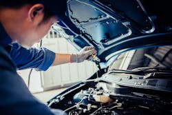 Automotive technician checks oil Automotive technician checks oil