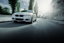 White BMW 3 Series F30 car is driving on asphalt road at summer daytime White BMW 3 Series F30 car is driving on asphalt road at summer daytime