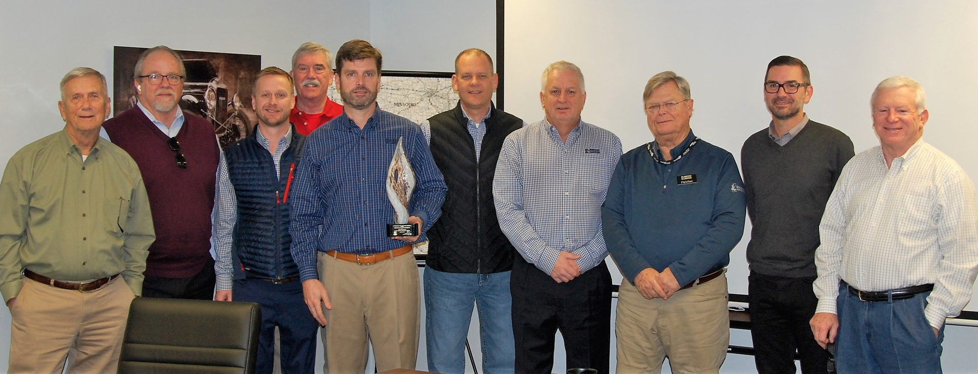 (L-R) Bobby Lord, director; Brian Dean, VP purchasing; Crow Lord, VP of sales; Tom Singleton, VP of store operations; Fletcher Lord, president (holding award); Kameron Spencer, VP of warehouse operations; Kenny Payne, VP of marketing; Fletcher Lord Jr., chairman of the board; Ben Butler, COO; Bill Schlatterer, CEO