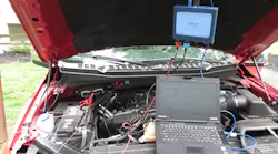 Under car's hood testing the battery
