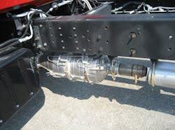 Full exhaust aftertreatment system mounted to the bottom of the chassis rail on an Isuzu 7500.