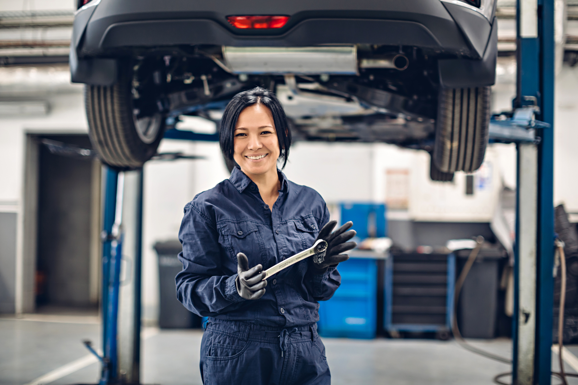Female mechanic smiling with wrench