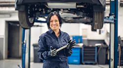 Female mechanic smiling with wrench